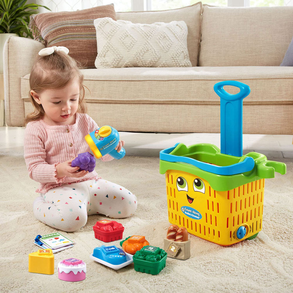 A little girl is playing with the Count-Along Basket & Scanner Pretend Play Toy by LeapFrog