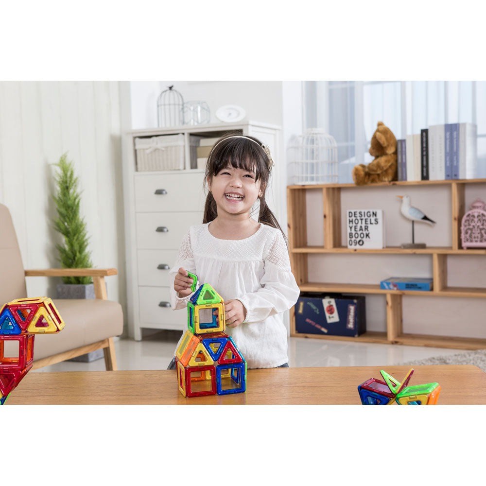 A little girl is playing with the Magformers Window Plus 20 Piece Magnetic Construction Set