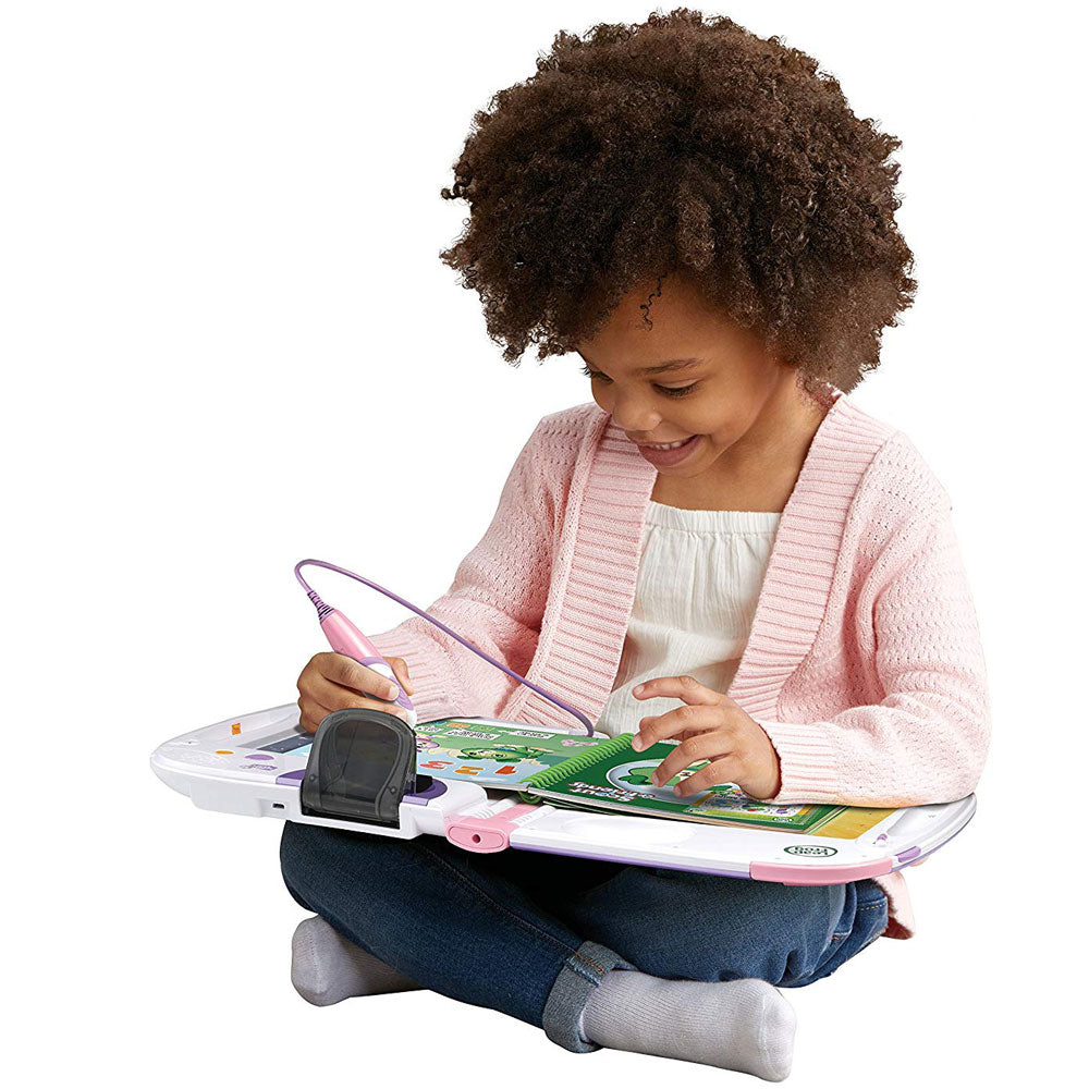 A girl is playing with the LeapStart Pink 3D Interactive Learning System by LeapFrog