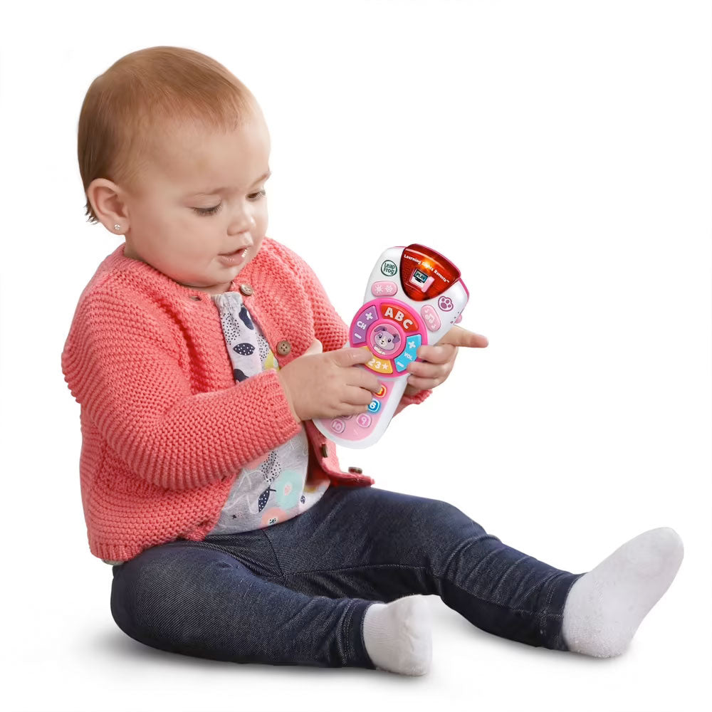 A baby is playing with the Violet's Learning Lights Remote pretend play toy by LeapFrog