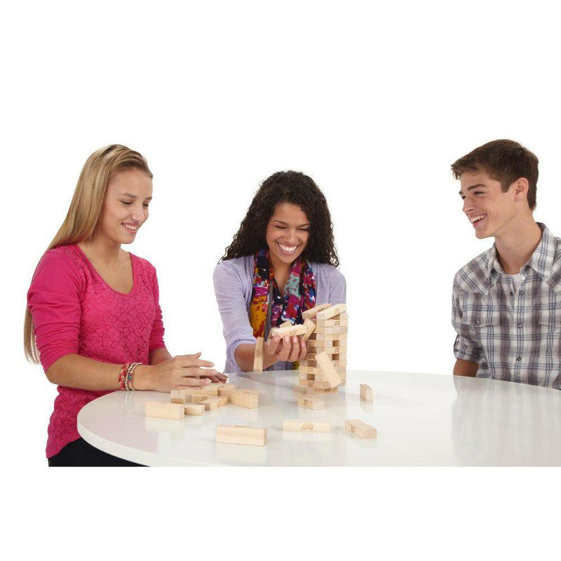 Three people playing Jenga, carefully removing a block from the tower